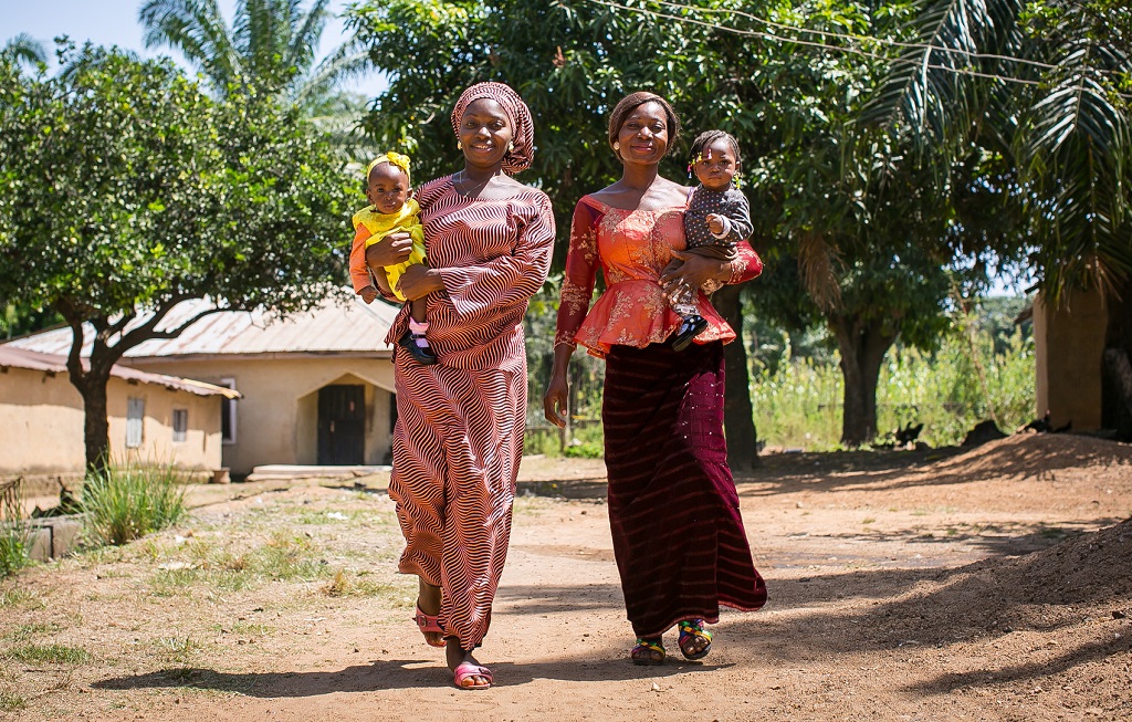 Two Nigerian women carrying their young children